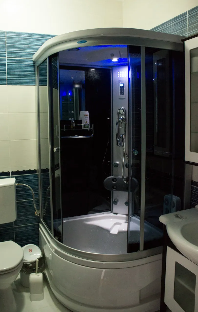 An enclosed shower cabin with glass doors, in the apartment's private bathroom